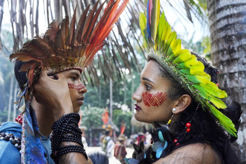 Apolima-Arara Indigenous youth Ozileia Macedo, right, puts face paint on Antonio Acassio Avelino de Oliveira, during the annual celebration recognizing the Ashaninka territory in the Apiwtxa village, Acre state, Brazil, Monday, June 24, 2024. (AP Photo/Jorge Saenz)