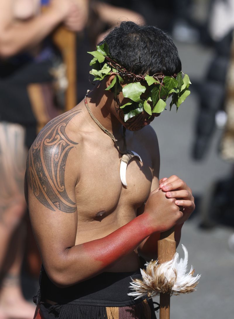 A warriors wait to receive the body of the Māori king, Kingi Tuheitia, next to the Waikato River where he will be carried up Taupiri Mountain for burial at Ngaruawahia, New Zealand, Thursday, Sept 6, 2024. (AP Photo/Alan Gibson)