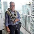 Daniel Gammerman poses for a photo on his balcony where he sometimes prays as he prepares to worship at home for the Jewish High Holy Days, Thursday, Sept. 26, 2024, in Miami. (AP Photo/Wilfredo Lee)