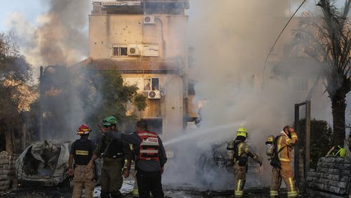 Israeli security and rescue forces work at the site hit by a rocket fired from Lebanon, in Kiryat Bialik, northern Israel, on Sunday, Sept. 22, 2024. (AP Photo/Gil Nechushtan)