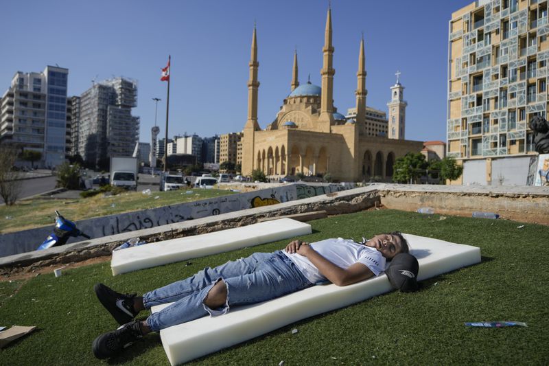 A boy sleeps in Beirut's Martyrs' square after fleeing the Israeli airstrikes in the southern suburbs of Dahiyeh, Sunday, Sept. 29, 2024. (AP Photo/Bilal Hussein)