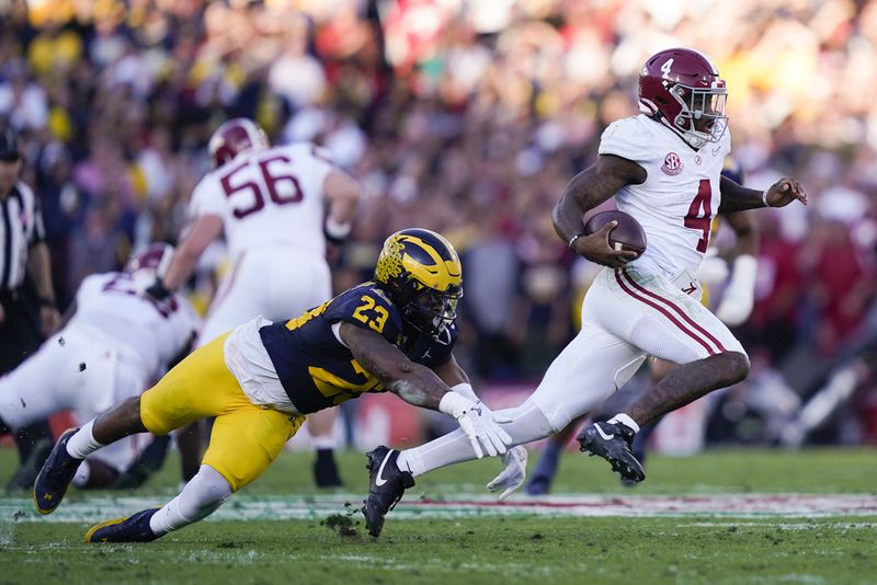 Alabama quarterback Jalen Milroe (4) runs past Michigan linebacker Michael Barrett (23) during the second half in the Rose Bowl CFP NCAA semifinal college football game Monday, Jan. 1, 2024, in Pasadena, Calif. (AP Photo/Ryan Sun)