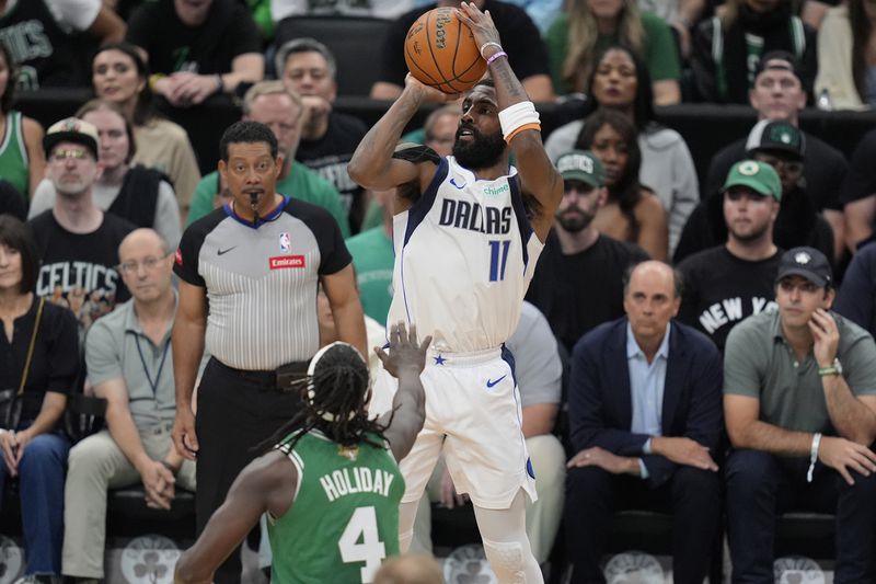 Dallas Mavericks guard Kyrie Irving (11) looks to shoot over Boston Celtics guard Jrue Holiday (4) during the first half of Game 5 of the NBA basketball finals, Monday, June 17, 2024, in Boston. (AP Photo/Charles Krupa)