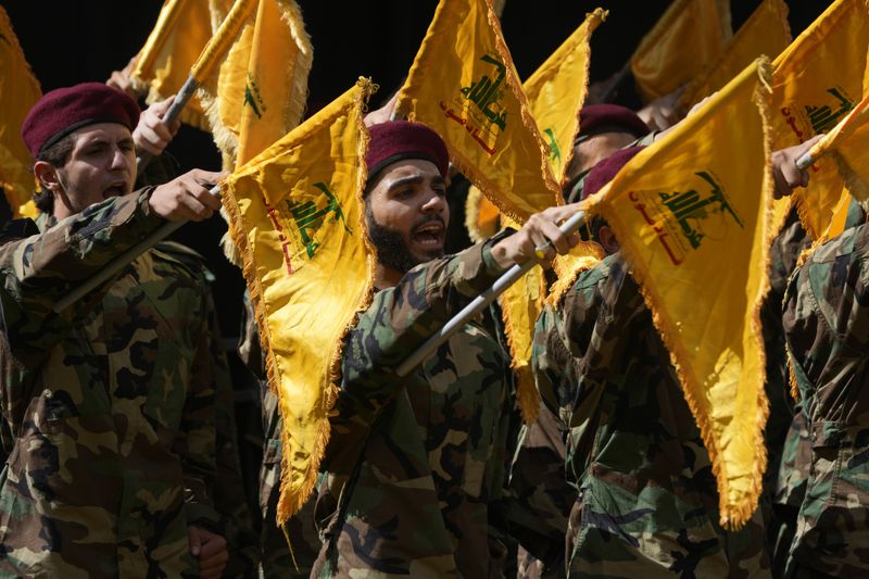 Hezbollah members attend the funeral of two of their comrades who were killed on Wednesday when a handheld device exploded, during a funeral procession in the southern suburbs of Beirut, Thursday, Sept. 19, 2024. (AP Photo/Hussein Malla)