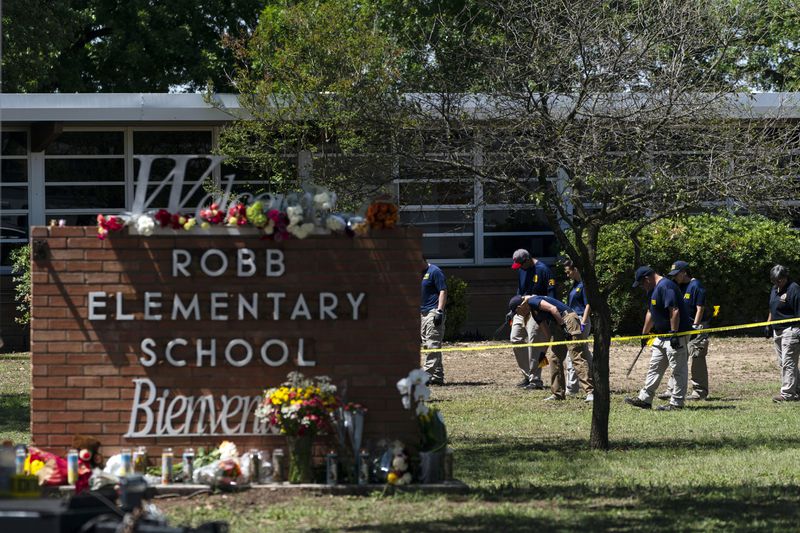FILE - Investigators search for evidences outside Robb Elementary School in Uvalde, Texas, May 25, 2022, following a shooting at the school. The families of 19 people who were killed or injured in the shooting and their attorneys are set to make an announcement, Wednesday, May 22, 2024. Friday will mark the two-year anniversary of the shooting where a gunman killed 19 students and two teachers (AP Photo/Jae C. Hong, File)