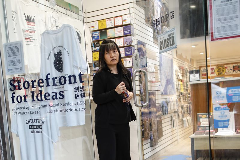 Beatrice Chen, executive director of Immigrant Social Services, closes the door to Storefront for Ideas, Thursday, Aug. 8, 2024, in New York. (AP Photo/Kena Betancur)