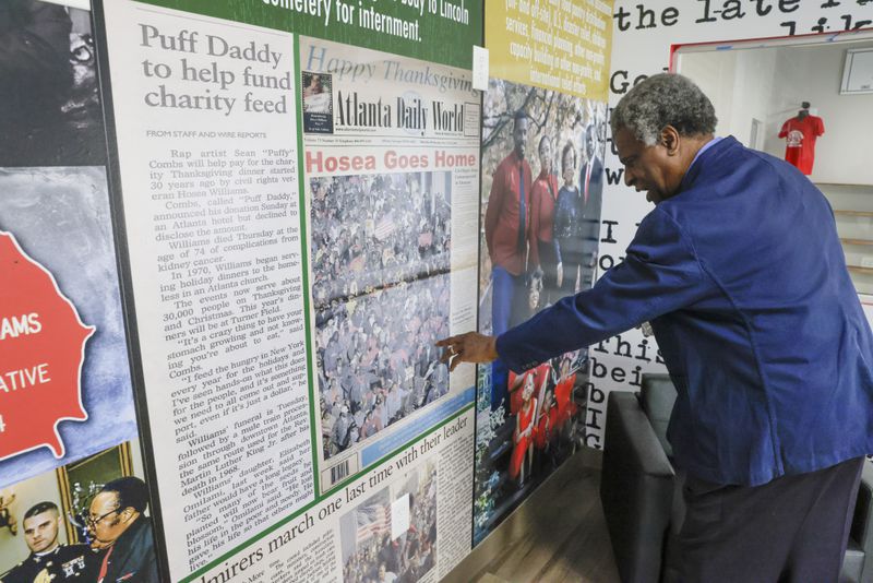 Afemo Omilami, who runs Hosea Helps with his wife, Elisabeth, reminisces while looking at timeline displays in the client room at the new Atlanta facility for the organization. (Bob Andres / bandres@ajc.com)