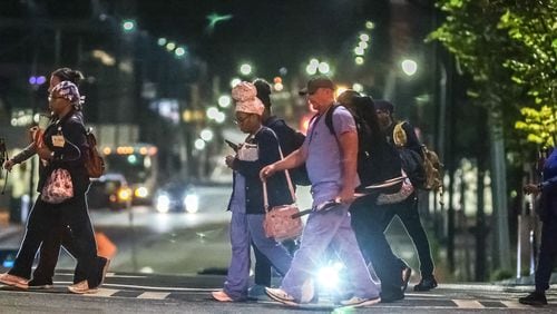 Atlantans make their way to work early Thursday morning, some with umbrella in-hand, as Tropical Storm Francine's outer bands of rain reach the city.