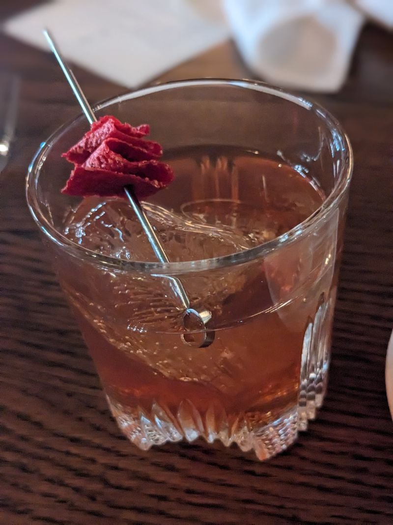 The Pigalle cocktail, which features bourbon, Calvados and a fruit leather garnish, is a delicious variation on a Manhattan. Courtesy of Paula Pontes