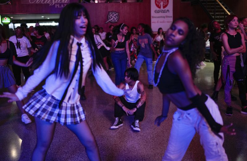 Dancer Francisco Piedra, 24, known by the stage name "Ken" rests on the floor as teenagers dance to K-pop, popular Korean music, at a cultural house in Havana, Cuba, Saturday, Sept. 7, 2024. (AP Photo/Ramon Espinosa)