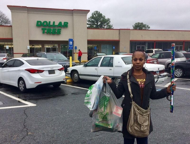 Tyree McGhee leaves a Dollar Tree in south DeKalb County with bags stuffed with 40 items. “It’s good for people who don’t have money,” she said. Photo by Bill Torpy