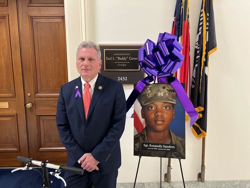 U.S. Rep. Buddy Carter, R-St. Simon Island, poses beside a poster with the photo of Sgt. Kennedy Sanders, an Army reservist from Waycross who was killed during a Jan. 28 drone attack in Jordan. (Courtesy photo)