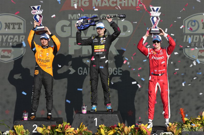 Colton Herta, center, holds his winner's trophy as Pato O'Ward, left, holds his second-place trophy and Josef Newgarden, right, holds his third-place trophy after an IndyCar auto race Sunday, Sept. 15, 2024, at Nashville Superspeedway in Lebanon, Tenn. (AP Photo/Mark Humphrey)