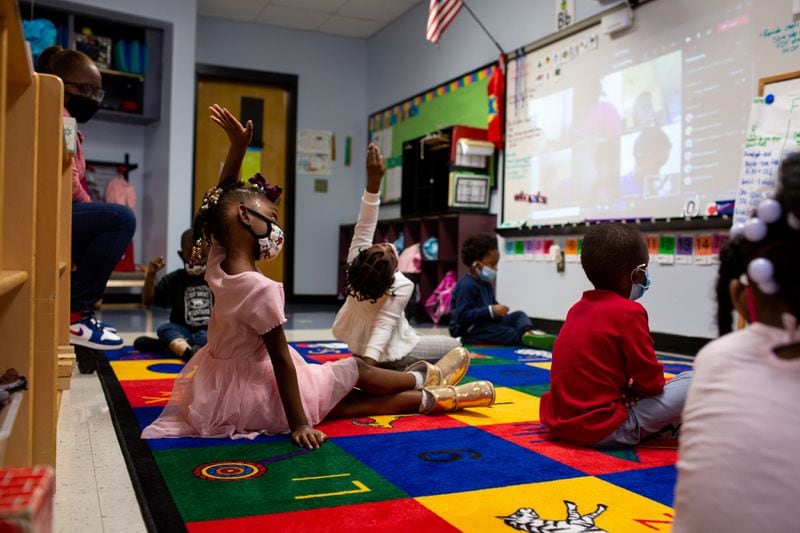 Kennedi Hill (left) and Fawziyah Fatunbi (center) raise their hands at Liberty Point Elementary School in Union City on Friday, Oct. 16, 2020. Micahiah Drake is a first-year pre-K teacher at Liberty Point Elementary School and has had to adjust her teaching style because of the coronavirus pandemic. (Rebecca Wright for The Atlanta Journal-Constitution)