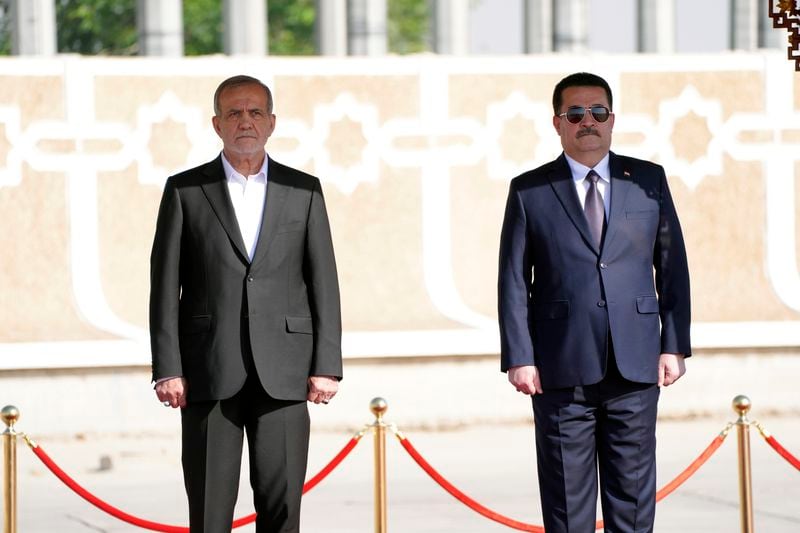 Iranian President Masoud Pezeshkian is welcomed by Iraqi Prime Minister Mohammed Shia al-Sudani, right, with an official ceremony at the Baghdad International Airport in Baghdad, Iraq, Wednesday Sept. 11, 2024. (Murtadha Al-Sudani/Pool Photo via AP)