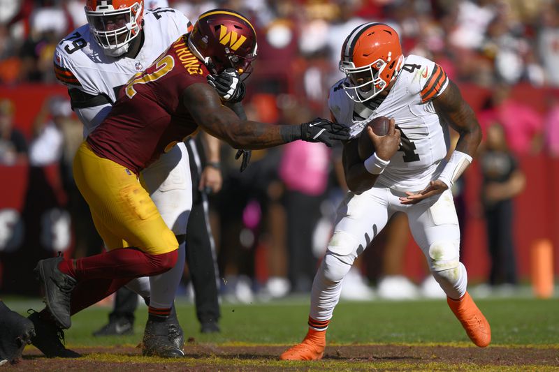 Cleveland Browns quarterback Deshaun Watson (4) break away from Washington Commanders defensive end Dorance Armstrong (92) during the second half of an NFL football game in Landover, Md., Sunday, Oct. 6, 2024. (AP Photo/Nick Wass)