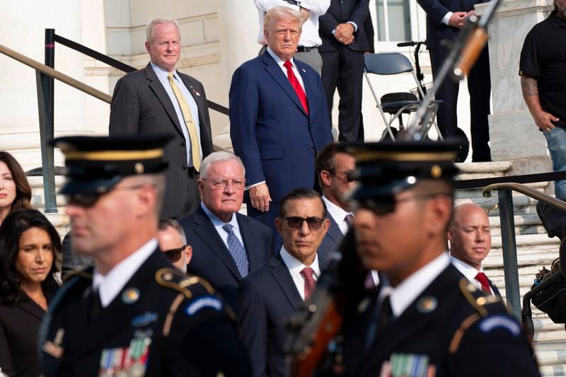 Bob Quackenbush, top left, deputy chief of staff for Arlington National Cemetery, and Republican presidential nominee former President Donald Trump watch the changing of the guard at the Tomb of the Unknown Solider at Arlington National Cemetery, Monday, Aug. 26, 2024, in Arlington, Va. (AP Photo/Alex Brandon)