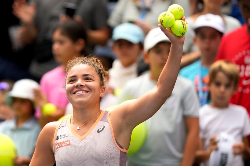 Jasmine Paolini, of Italy, prepares to hit autographed balls to fans after advancing to the next round when opponent Karolina Pliskova, of the Czech Republic, retired during the second round of the U.S. Open tennis championships, Thursday, Aug. 29, 2024, in New York. (AP Photo/Kirsty Wigglesworth)