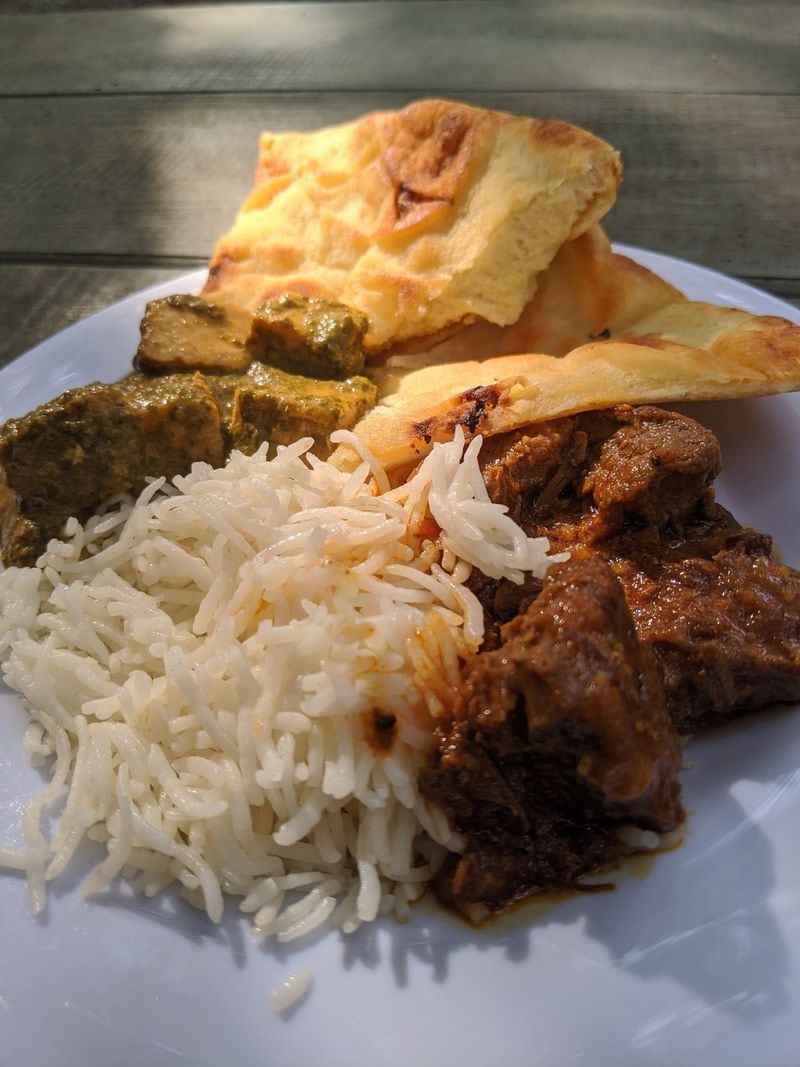 Chai Pani offers an abbreviated takeout menu of Indian favorites, including saag paneer (left) and lamb vindaloo (right), with fresh naan and basmati rice. CONTRIBUTED BY PAULA PONTES
