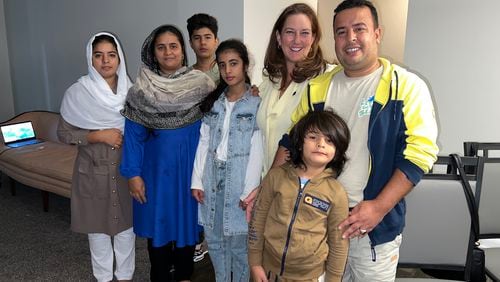 Arif Safi, far right, poses with his wife Zainab, second from left, the couple's four children, and Jennifer Glasse on the Afghan's family first full day in metro Atlanta, Wednesday, September 11, 2024.