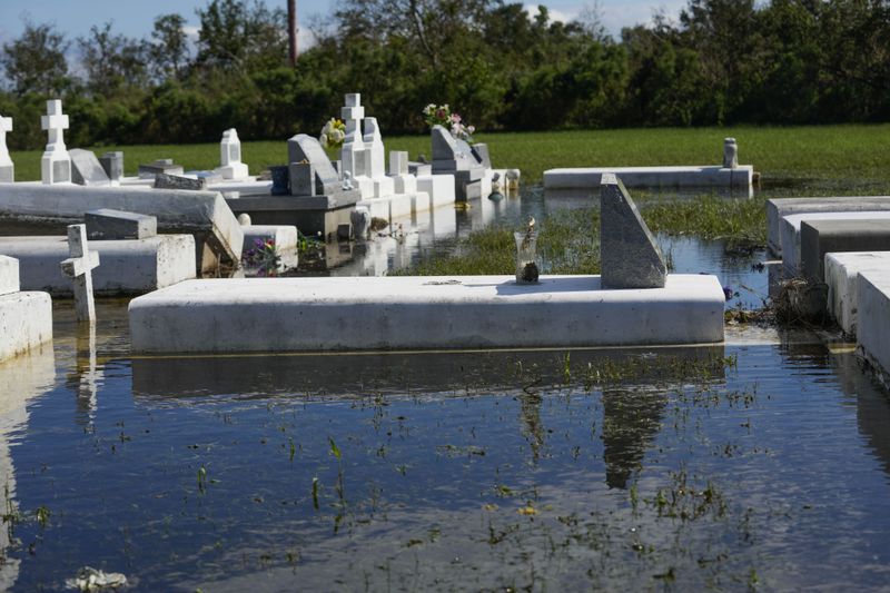 Tombs are seen after being disturbed by flooding, in the aftermath of Hurricane Francine, in Dulac, La., Thursday, Sept. 12, 2024. (AP Photo/Gerald Herbert)