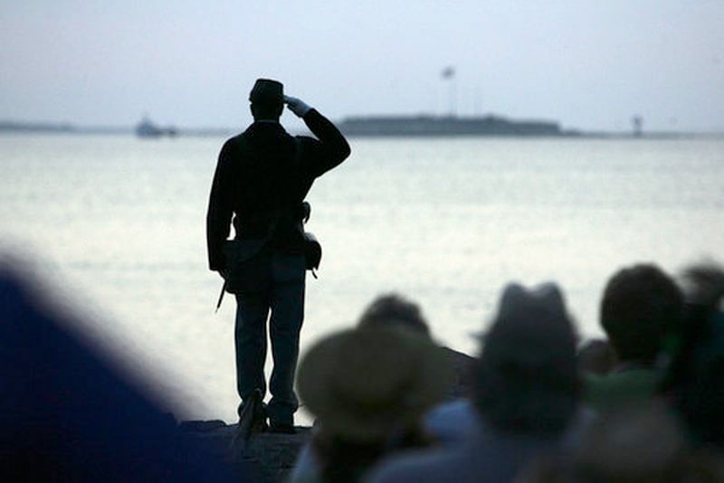 CIVIL WAR ANNIVERSARY--Ernest Parks, a re-enactor from Company I, Massachusetts 54th Regiment, salutes after tossing a wreath into Charleston Harbor toward Fort Sumter, seen in background, during commemoration of the 150th anniversary of the start of the Civil War, Tuesday, April 12, 2011.
