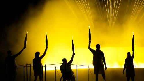 Athletes Charles-Antoine Kouakou, Nantenin Keita, Fabien Lamirault, Alexis Hanquinquant and Elodie Lorandi look up after they lit the cauldron during the Opening Ceremony for the 2024 Paralympics, Wednesday, Aug. 28, 2024, in Paris, France. (AP Photo/Christophe Ena)