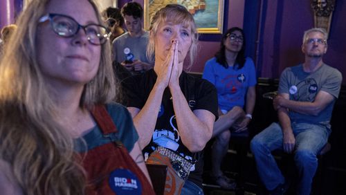 Lori Lahrmann left, and Tonya Morris, second from left, both from Cincinnati, watch the presidential debate between President Joe Biden and Republican presidential candidate former President Donald Trump at Tillie's Lounge on Thursday, June 27, 2024, in Cincinnati. Both plan to vote for President Joe Biden. (AP Photo/Carolyn Kaster)