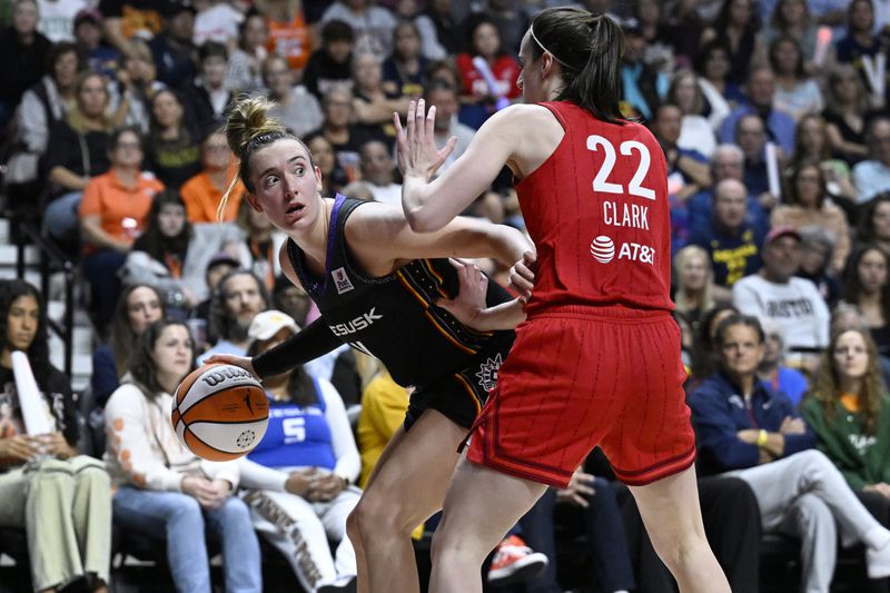 Connecticut Sun guard Marina Mabrey, left, is guarded by Indiana Fever guard Caitlin Clark during the second half of a first-round WNBA basketball playoff game, Wednesday, Sept. 25, 2024, in Uncasville, Conn. (AP Photo/Jessica Hill)