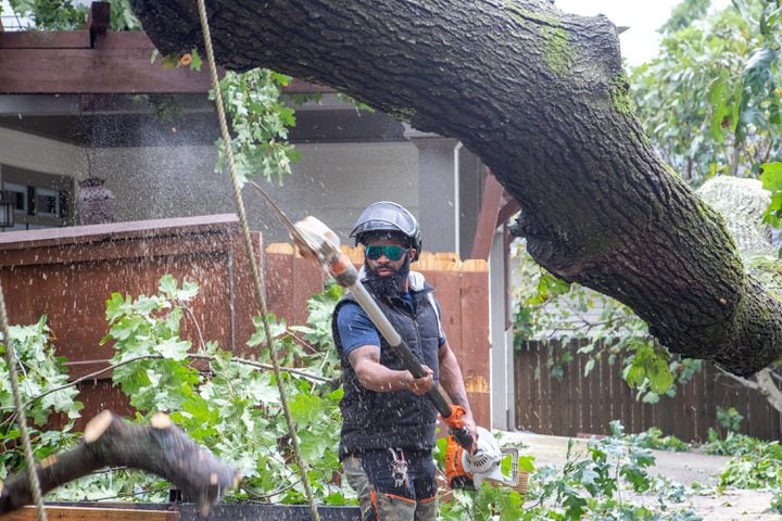 Dad’s Tree Service’s Anthony Ray works to remove an oak tree from a Kirkwood home on Friday, Sept 27, 2024 after it fell on around 5:45 am during hurricane Helene.  Several homes were damaged in this area with multiple large oak trees falling in backyards. No one was hurt and residents are waiting for insurance adjusters to arrive.  (Jenni Girtman for The Atlanta Journal-Constitution)