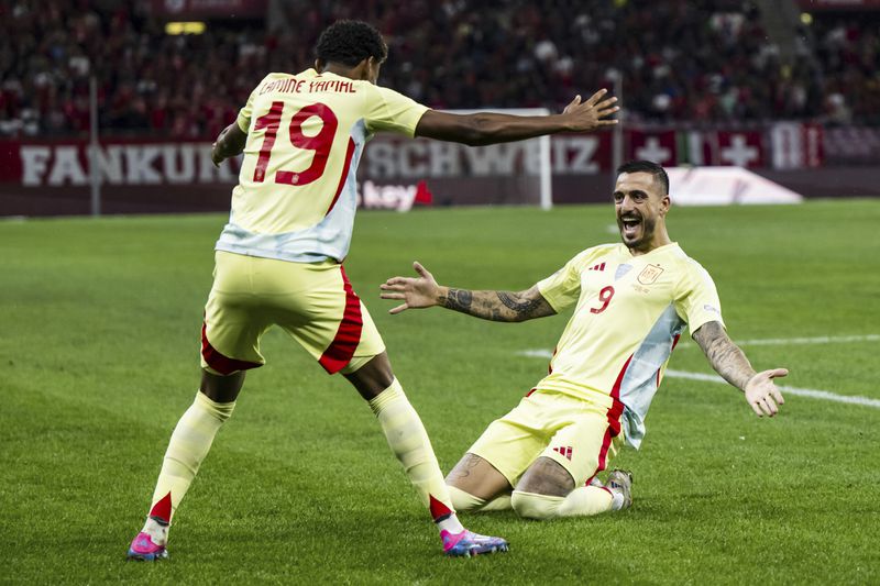 Spain's forward Joselu, right, celebrates after scoring the first goal with Spain's forward Lamine Yamal, left during the Nations League group A4 qualifying soccer match between Switzerland and Spain, at the Stade de Geneve, in Geneva, Sunday, Sept. 8, 2024. (Jean-Christophe Bott/Keystone via AP)