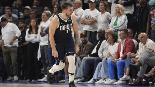 Dallas Mavericks guard Luka Doncic (77) celebrates a score against the Minnesota Timberwolves during the second half in Game 1 of the NBA basketball Western Conference finals, Wednesday, May 22, 2024, in Minneapolis. (AP Photo/Abbie Parr)