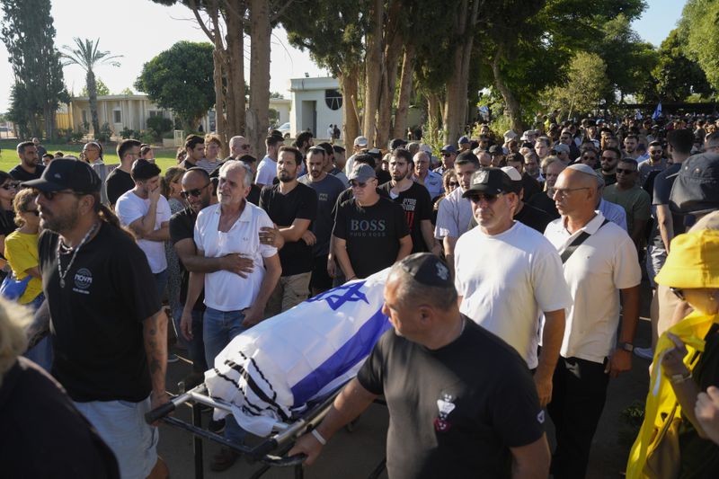 Relatives and friends attend the funeral of slain hostage Almog Sarusi, who was killed in Hamas captivity in the Gaza Strip, at a cemetery in Ra'anana, Israel, Sunday, Sept. 1, 2024. (AP Photo/Ariel Schalit)