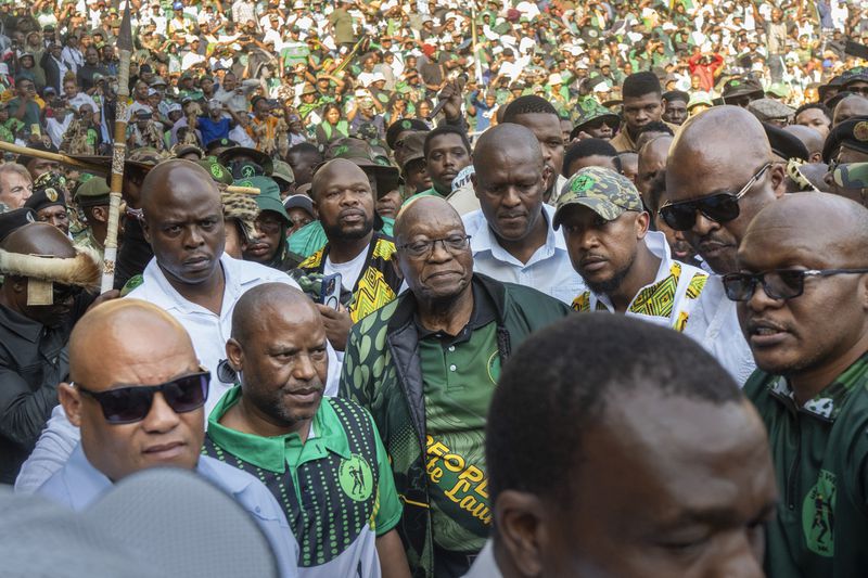 FILE — Former South African President Jacob Zuma, centre, arrives at Orlando stadium in Soweto, Johannesburg, South Africa, for the launch of his newly formed uMkhonto weSizwe (MK) party's manifesto Saturday, May 18, 2024. Several polls have the African National Congress' support below 50% ahead of next Wednesday's, May 29, 2024 vote, raising the prospect that it might not be the majority party for the first time since Nelson Mandela led it to victory in the first all-race elections that ended white minority rule in 1994. (AP Photo/Jerome Delay, File)