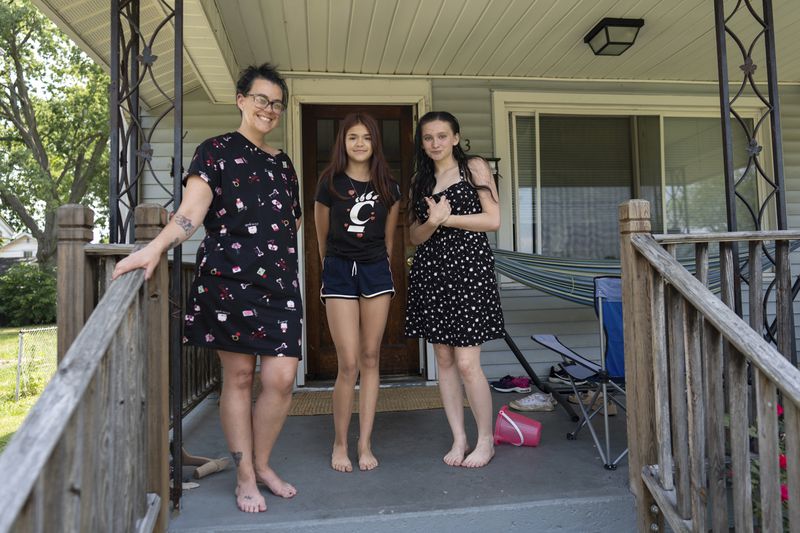 Amanda Bailey, 35, from left, stands on her front porch with her daughters Raelyn Mohler, 13, and Lilah Martin, 16, on Friday, June 21, 2024, in Middletown, Ohio. This house, where Bailey and her family live, is the same house where "Hillbilly Elegy" author Sen. J.D. Vance, R-Ohio, grew up. Bailey said she thought “Hillbilly Elegy” nailed it, and that former President Donald Trump and Vance would “make a great team.” (AP Photo/Carolyn Kaster)