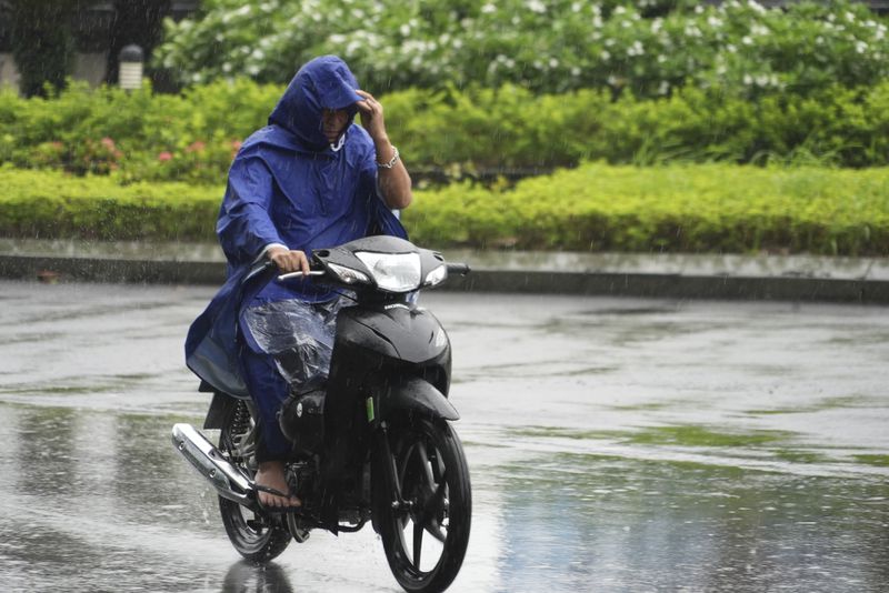 A man rides motorcycle in the rain caused by typhoon Yagi in Hanoi, Vietnam on Sep. 7, 2024. (AP Photo/Hau Dinh)