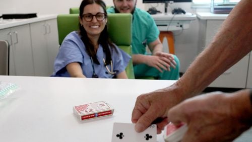 Retired gastroenterologist Gary Poleynard, performs a card trick for medical residents as he visits patients at the Memorial Health Dwaine and Cynthia Willett Children’s Hospital of Savannah on Friday, October 13, 2023.