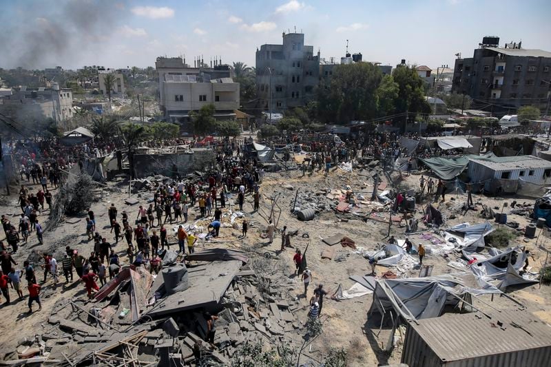 Palestinians inspect the damage at a site hit by an Israeli bombardment on Khan Younis, southern Gaza Strip, Saturday, July 13, 2024. Israel said it targeted Hamas' shadowy military commander in a massive strike Saturday in the crowded southern Gaza Strip that killed at least 71 people, according to local health officials. Hamas immediately rejected the claim that Mohammed Deif was targeted. (AP Photo/Jehad Alshrafi)