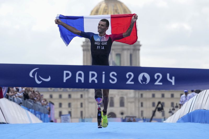 France's Alexis Hanquinquant wins the men's PTS4 Triathlon at the 2024 Paralympics, Monday, Sept. 2, 2024, in Paris, France. (AP Photo/Thibault Camus)