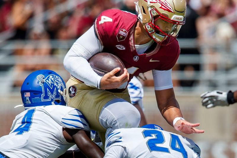 Florida State quarterback DJ Uiagalelei (4) tries to jump over Memphis defensive backs An'Darius Coffey (4) and Greg Rubin (24) during the first half of an NCAA college football game, Saturday, Sept. 14, 2024, in Tallahassee, Fla. (AP Photo/Colin Hackley)