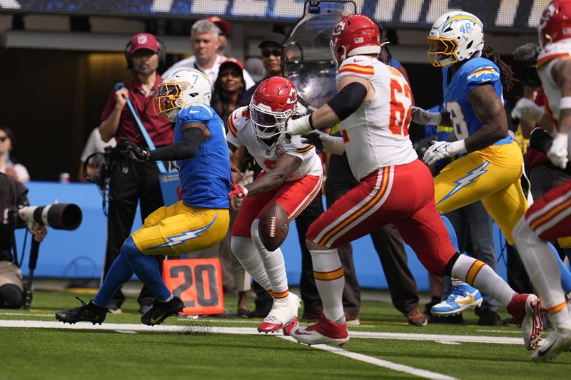 Los Angeles Chargers cornerback Kristian Fulton, left, fumbles the ball out of bounds after intercepting a pass as Kansas City Chiefs wide receiver Rashee Rice (4) defends during the first half of an NFL football game Sunday, Sept. 29, 2024, in Inglewood, Calif. (AP Photo/Marcio Jose Sanchez)