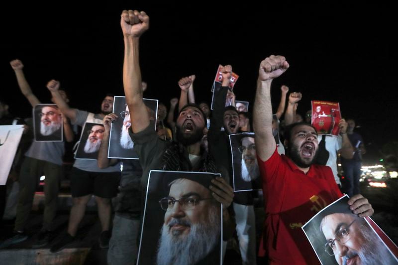 Lebanese and Palestinian men hold portraits of Hezbollah leader Sayyed Hassan Nasrallah, as they shout slogans during a protest in the southern port city of Sidon, Lebanon, Saturday, Sept. 28, 2024. (AP Photo/Hussein Malla)