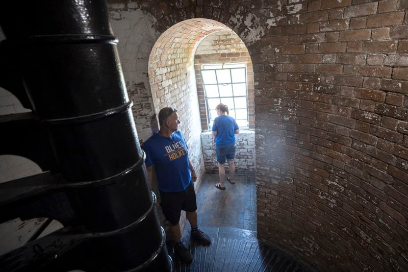 Two visitors stop to check out one of the Tybee Island lighthouse's windows that light the spiral stairs to the top of the 145-foot landmark on Georgia's coast on May 23, 2024. The Tybee Island Historical Society is making repairs to the 18th century lighthouse. (AJC Photo/Stephen B. Morton)