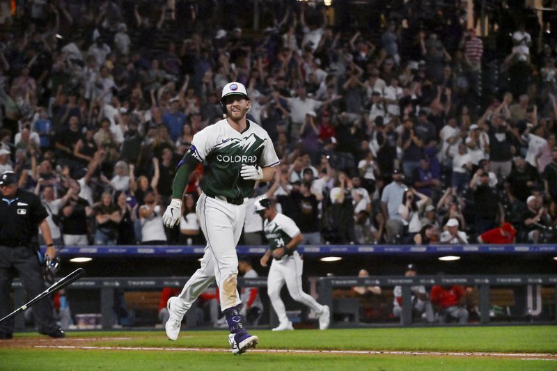 Colorado Rockies' Ryan McMahon tosses his bat after earning a bases-loaded walk to score the winning run against the Washington Nationals in a baseball game Saturday, June 22, 2024, in Denver. (AP Photo/Geneva Heffernan)