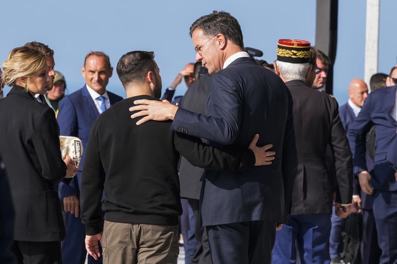 FILE - Ukrainian President Volodymyr Zelenskyy, left, talks to Netherland's Prime Minister Mark Rutte at the end of an international ceremony to mark the 80th anniversary of D-Day at Omaha Beach in Saint-Laurent-sur-Mer, Normandy, France, Thursday, June 6, 2024. Over the course of more than a dozen years at the top of Dutch politics, Mark Rutte got to know a thing or two about finding consensus among fractious coalition partners. Now he's going to bring the experience of leading four Dutch multiparty governments to the international stage as NATO's new secretary general. (AP Photo/Virginia Mayo, File)