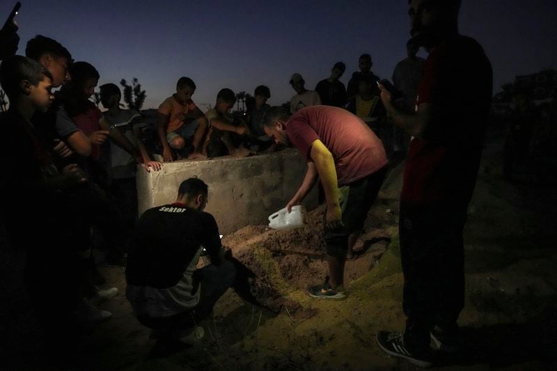 Palestinian mourners bury their loved one at the cemetery in Deir al-Balah, Gaza Strip, Friday, Aug. 9, 2024. (AP Photo/Abdel Kareem Hana)