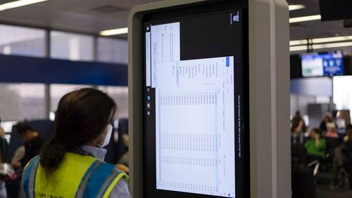 A technician works on an information display near United Airlines gates at Chicago O'Hare International Airport in Chicago, Friday, July 19, 2024, after a faulty CrowdStrike update caused a major internet outage for computers running Microsoft Windows. (AP Photo/Carolyn Kaster)