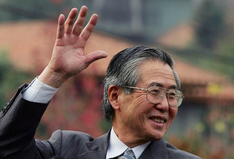 FILE - Former Peru's President Alberto Fujimori waves at his home in Santiago after leaving the academy for the training of corrections officers in Santiago, Chile, May 18, 2006. (AP Photo/Claudio Santana, File)