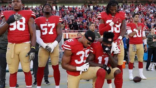 San Francisco 49ers safety Eric Reid (35) and wide receiver Marquise Goodwin (11) kneel during the performance of the national anthem before an NFL football game against the New York Giants in Santa Clara, Calif., Sunday, Nov. 12, 2017. (AP Photo/Marcio Jose Sanchez)