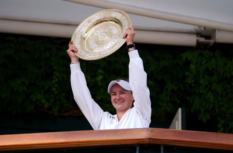 Barbora Krejcikova of the Czech Republic holds up the winners trophy on a balcony of centre court after she defeated Jasmine Paolini of Italy in the women's singles final at the Wimbledon tennis championships in London, Saturday, July 13, 2024. (John Walton/PA via AP)